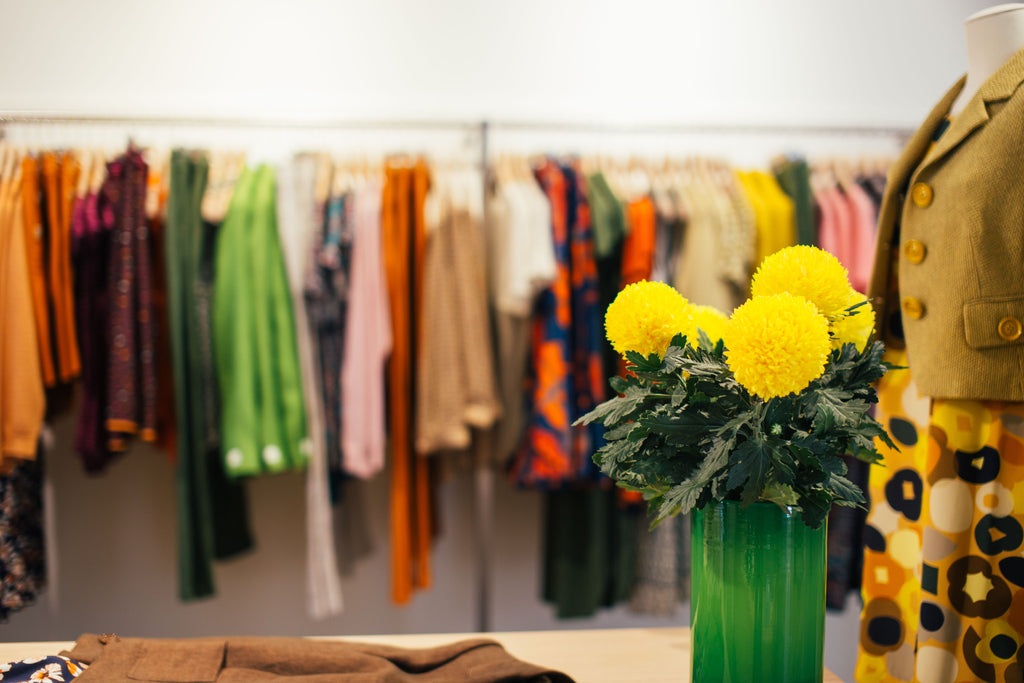 Colorful garments hanging on rails in a clothing shop